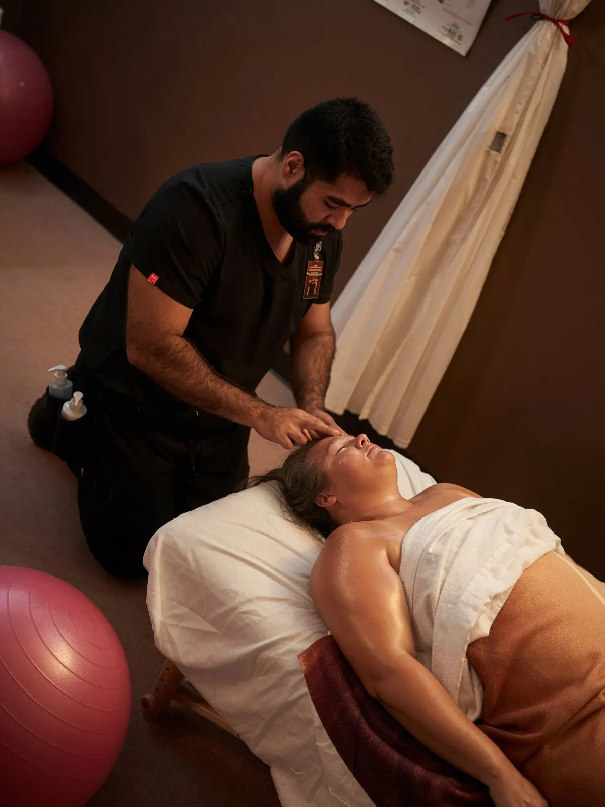 Male student massaging face of relaxed client — Texas Massage Academy, Brownwood TX