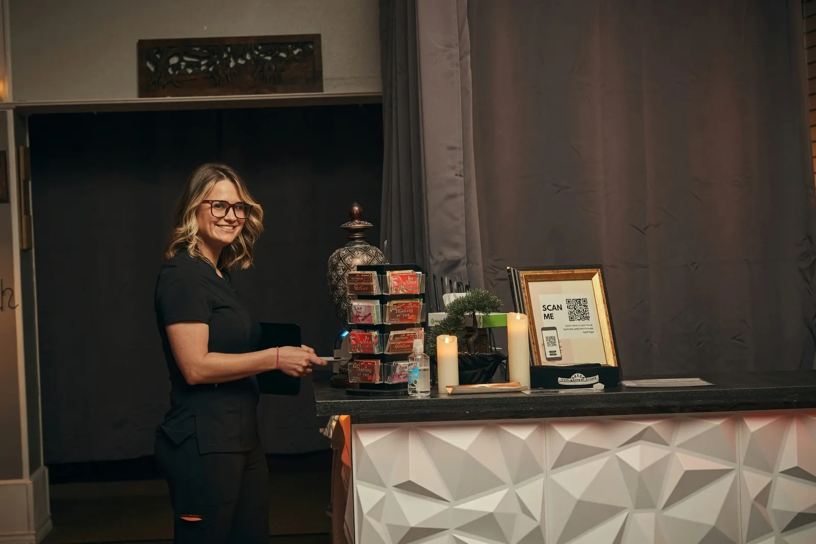 Smiling therapist at the day spa front desk with gift cards — Texas Massage Academy, Brownwood TX