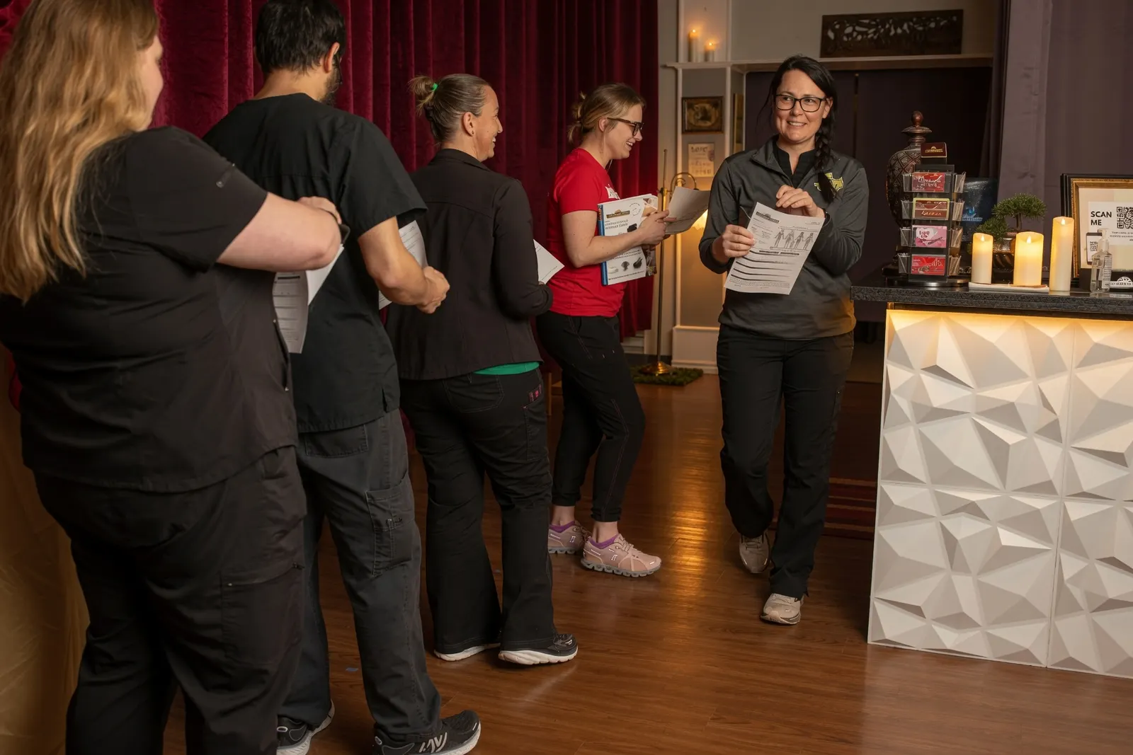 Students lined up with client intake paperwork in the spa lobby — Texas Massage Academy, Brownwood TX