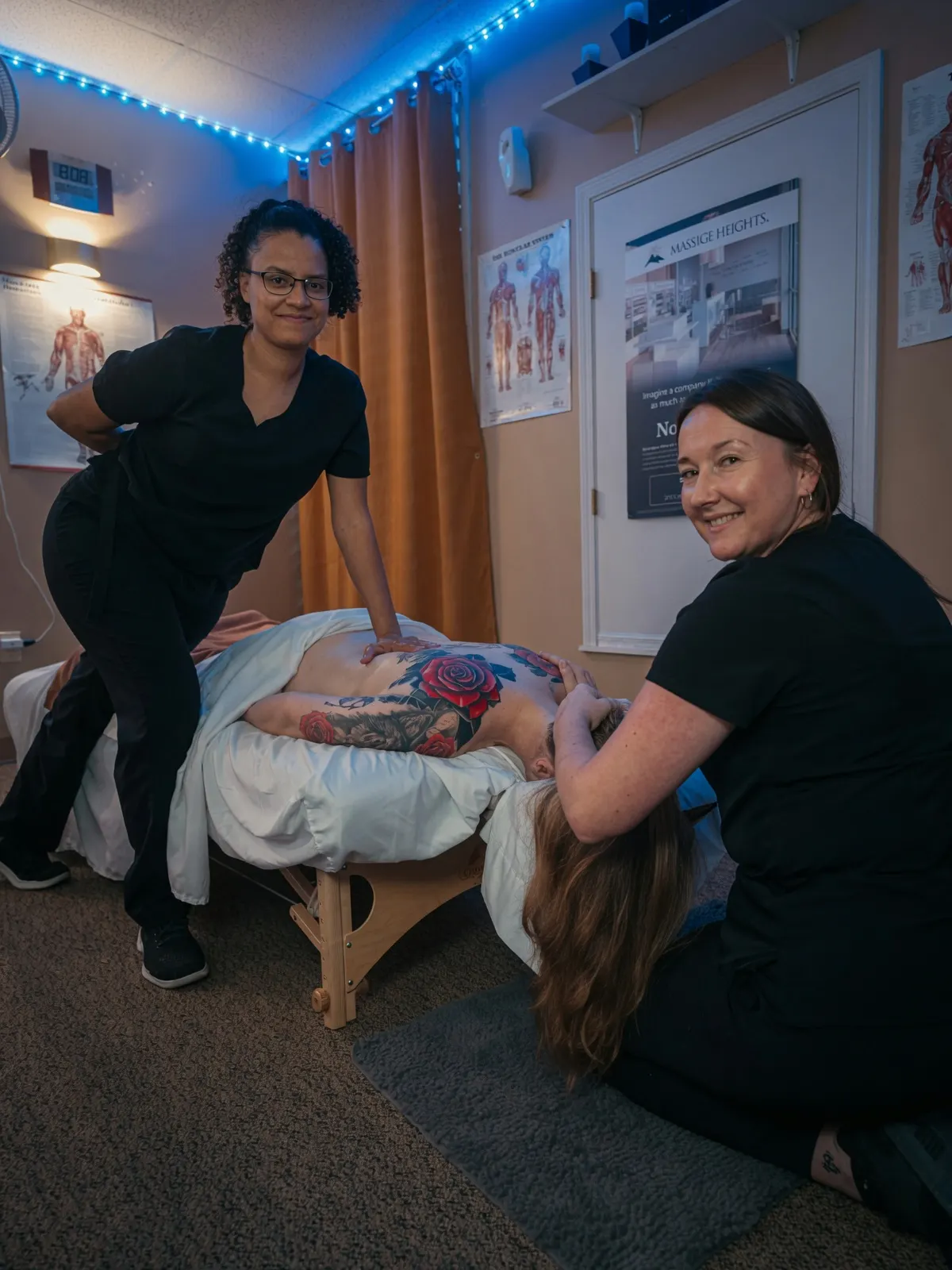 Two smiling students massaging tattooed client's back — Texas Massage Academy, Brownwood TX