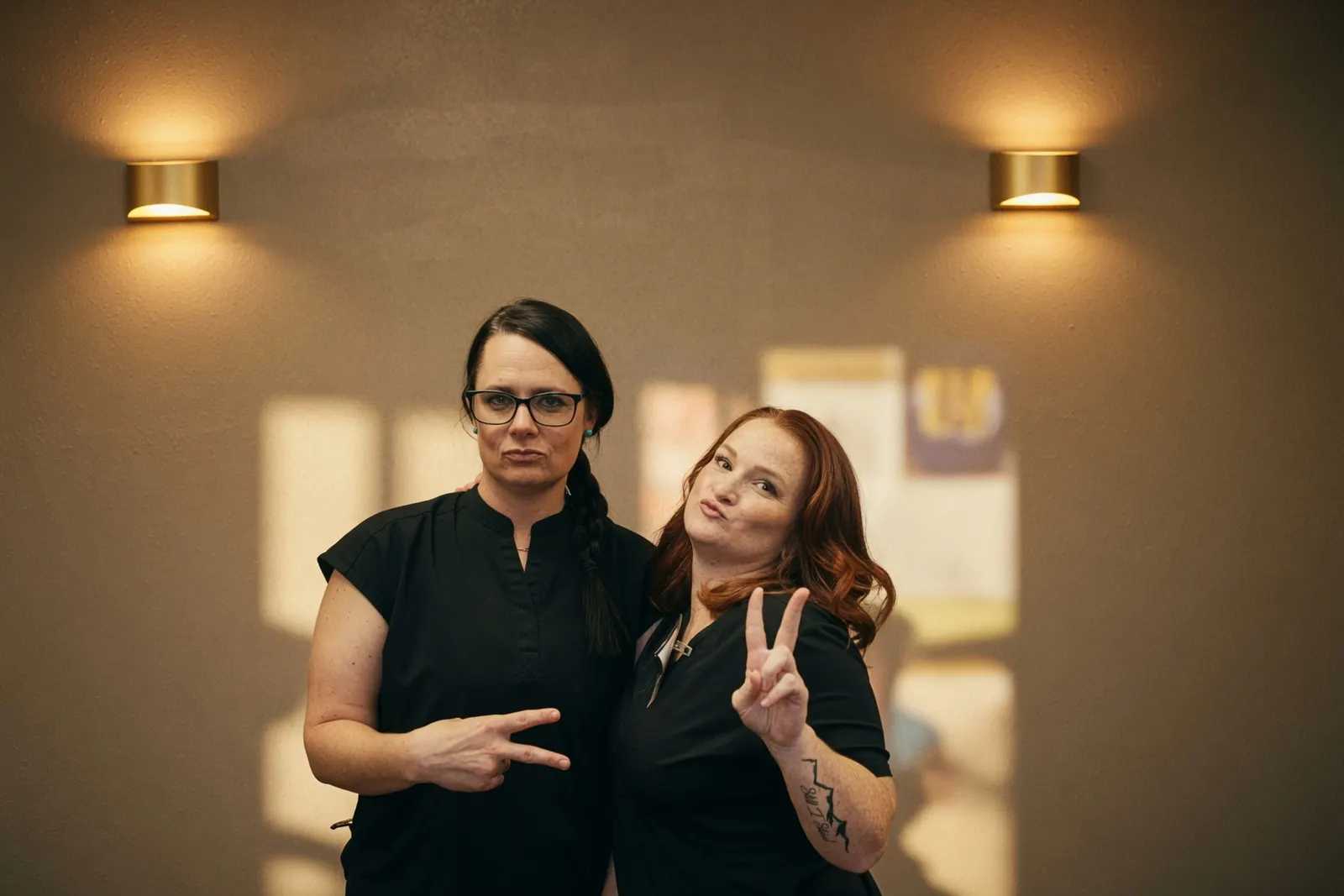 Two smiling massage therapist friends flashing peace signs — Texas Massage Academy, Brownwood TX