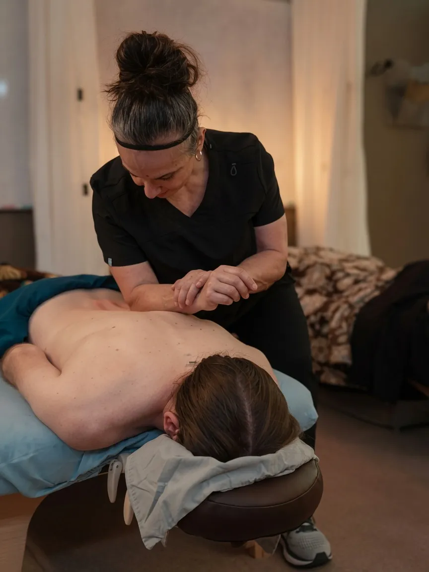 Student applying a deep tissue forearm technique to a client's back