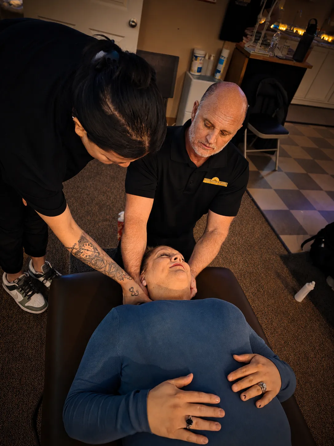 Instructor and student practicing a gentle neck technique on a client