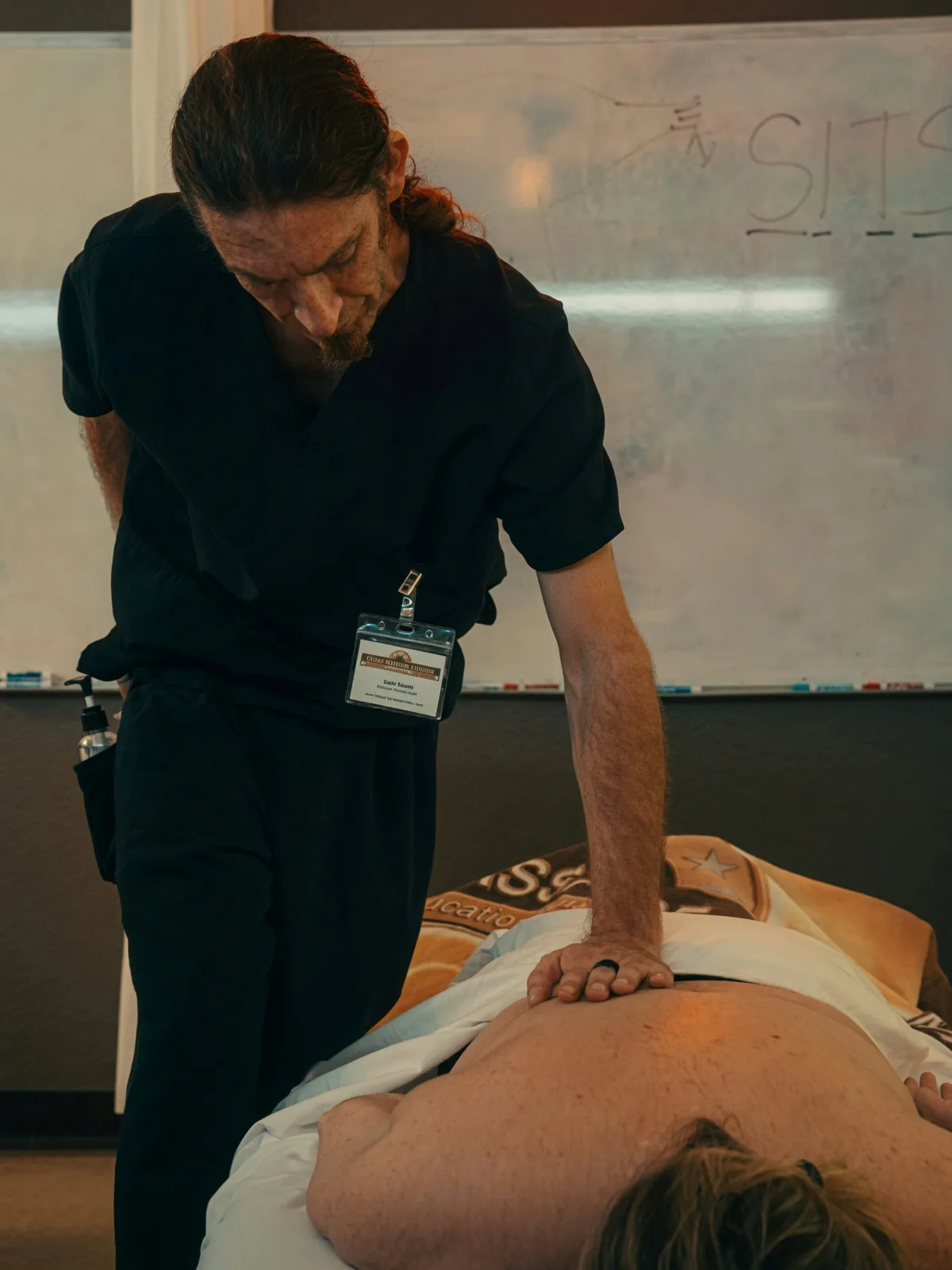 Massage student working the lower back of a client during hands-on technique practice at Texas Massage Academy