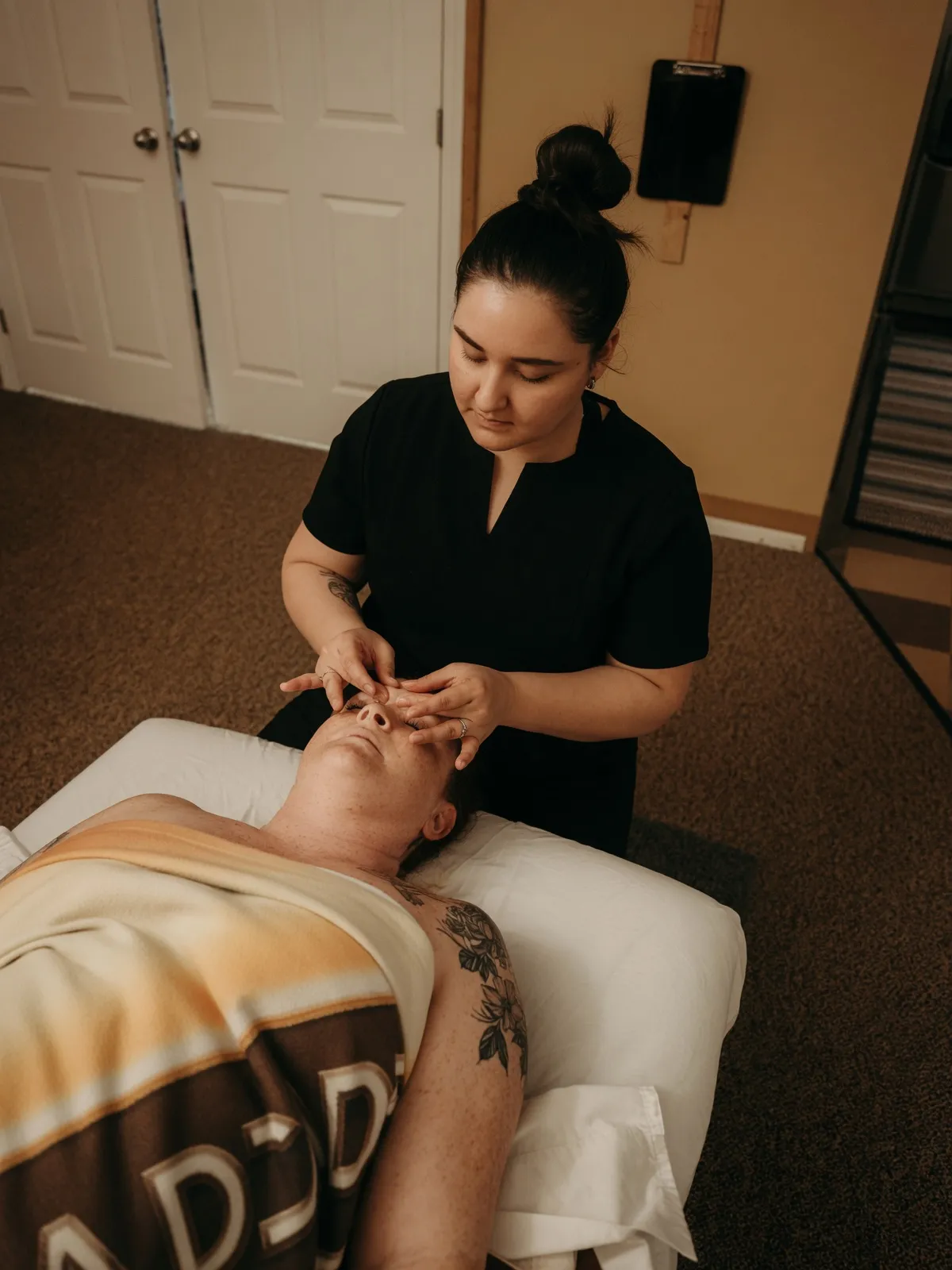 Student performing a facial pressure-point technique on a client