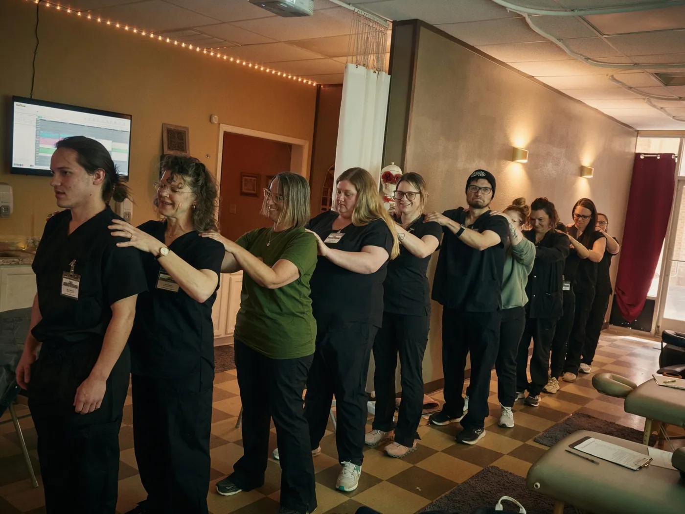 Texas Massage Academy students giving each other shoulder massages in a class circle, building a real community