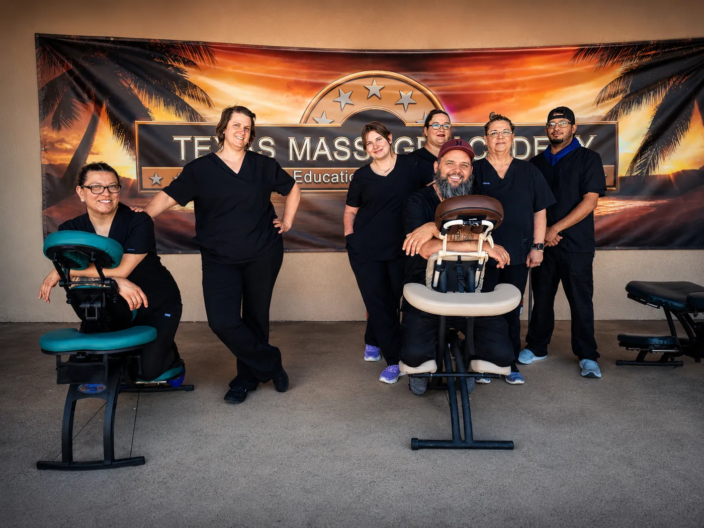 The Texas Massage Academy team in front of the school banner in Brownwood, Texas