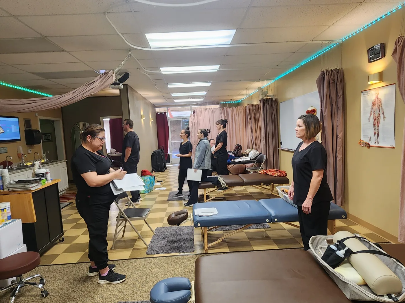 A real massage therapy class in session at the Texas Massage Academy Brownwood campus — students and instructors working in the clinic classroom