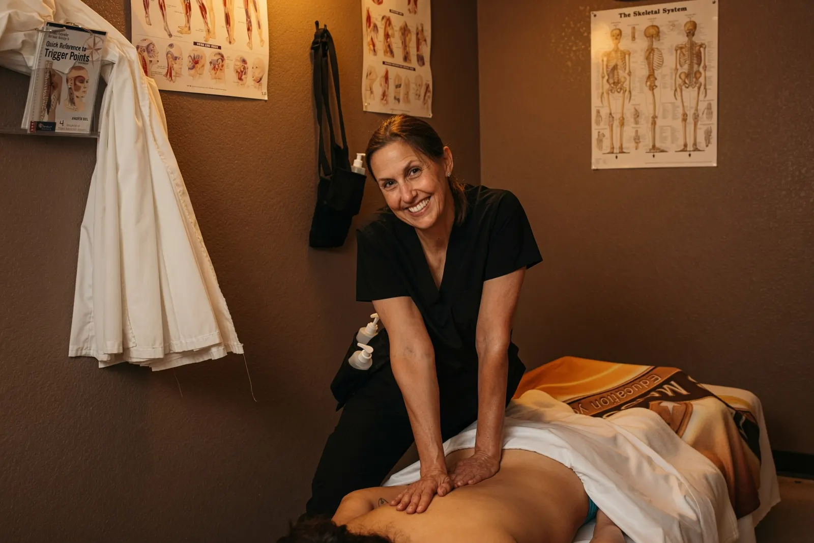 Smiling therapist giving a relaxing back massage in a treatment room at the Texas Massage Academy day spa in Brownwood, Texas