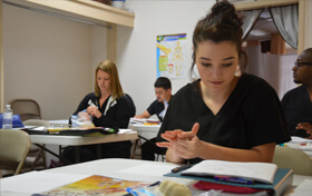 Female student making bones out of playdo at massage therapy school in Brownwood and Abilene Texas