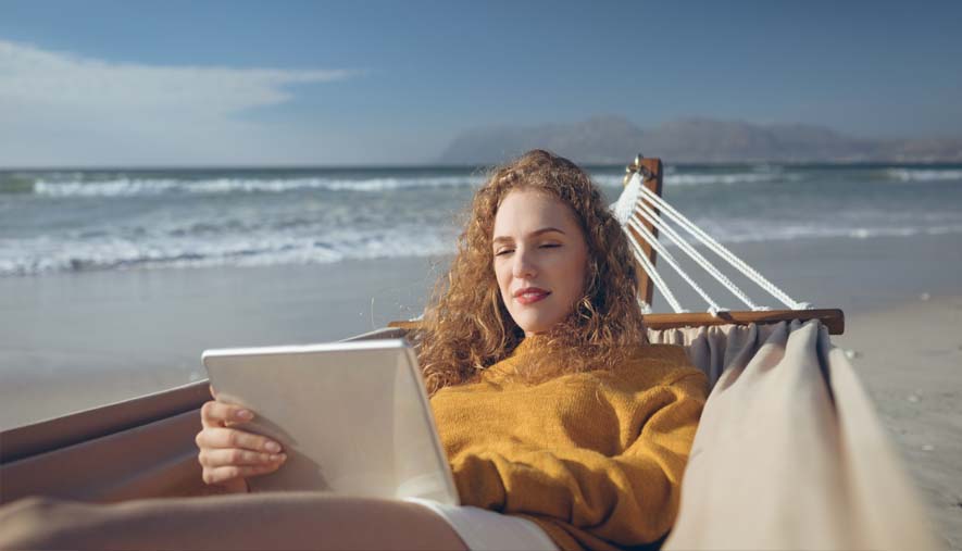 student from San Antonio at beach while using her mobile device for massage class